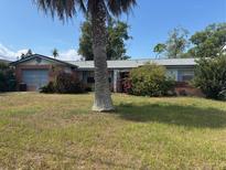 Single-story home featuring a blend of brick and siding, complemented by a well-maintained front yard at 977 E Normandy Blvd, Deltona, FL 32725