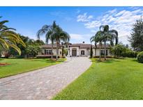 Stunning villa with a circular driveway, lush landscaping, and grand entrance at 10352 Burris Ct, Orlando, FL 32836