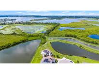 Stunning aerial view of the expansive property featuring multiple ponds and lush greenery, backing onto a large lake at 15208 Lake Claire Overlook Dr, Winter Garden, FL 34787