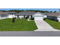 Charming single-story home with a well-maintained lawn and a two-car garage at 15476 Sw 34Th Court Rd, Ocala, FL 34473