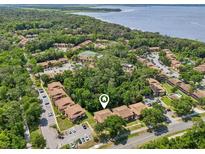 Aerial view of the community with lake view, surrounded by lush greenery and convenient parking at 168 Perimeter Ct # 5C, Deltona, FL 32725