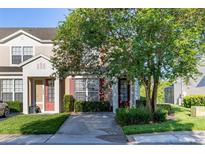 Charming townhome featuring a well-maintained lawn, mature trees, and inviting front entrance at 2346 Silver Palm Dr, Kissimmee, FL 34747