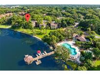 Stunning aerial view showcasing the community pool, lake, and dock at 2945 Lake Pineloch Blvd # 18-26, Orlando, FL 32806