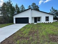 Charming single-story home features a black garage door and a well-manicured lawn at 3063 Sw 168Th Loop, Ocala, FL 34473