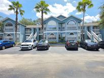 Inviting condo complex with blue siding, palm trees, and convenient parking spaces at 3157 Britannia Blvd # B, Kissimmee, FL 34747