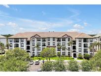 Beautiful condominium building with a tile roof, manicured landscaping, and ample parking at 4114 Breakview Dr # 30702, Orlando, FL 32819