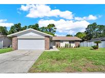 Charming single-story home featuring brick accents, a two-car garage, and a well-manicured lawn at 5210 Poinsetta Ave, Winter Park, FL 32792