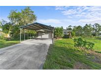 Charming single-story home featuring a covered parking area and well-maintained landscaping on a sunny day at 6975 Maverick Trl, St Cloud, FL 34771