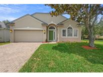 Charming single-story home featuring a well-manicured lawn and a neutral stucco exterior with a green front door at 714 Home Grove Dr, Winter Garden, FL 34787