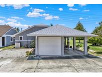 Home exterior featuring a carport, concrete driveway, and neutral gray siding with a well-manicured yard at 722 Ridgewood Way, Winter Springs, FL 32708