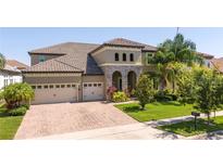 Beautiful two-story home showcasing a three-car garage and a brick-paved driveway at 8419 Pippen Dr, Orlando, FL 32836