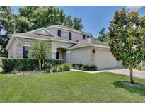 Charming two-story home with stone accents, manicured lawn, and mature landscaping under a clear blue sky at 9521 Southern Garden Cir, Altamonte Springs, FL 32714