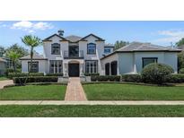Stunning two-story home featuring a manicured lawn and a symmetrical facade with a central balcony at 960 Brightwater Cir, Maitland, FL 32751