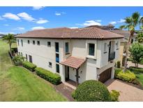 Stunning two-story home with a tile roof, manicured lawn, and meticulously landscaped yard at 970 Golden Bear Dr, Reunion, FL 34747