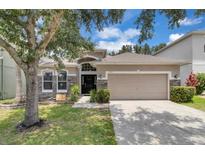 Charming single-Gathering home with a well-maintained lawn, beautiful stone accents, and a two-car garage at 10293 Cypress Knee Cir, Orlando, FL 32825