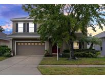 Charming two-story home with a two car garage, manicured lawn, and mature trees at 10337 Cypress Trail Dr, Orlando, FL 32825