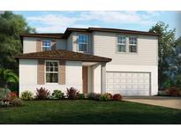 Charming two-story home with a two-car garage and a well-manicured lawn with colorful flower beds at 1140 Cumberland Trail Dr, Lake Hamilton, FL 33851