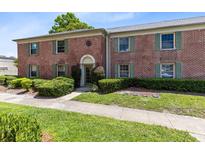 Charming two-story red brick townhome with green shutters and manicured landscaping at 117 Georgetown Dr # C, Casselberry, FL 32707
