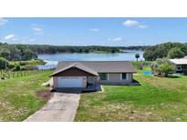 Inviting single-Gathering home on a sprawling lot with scenic lake views and a well-maintained lawn at 16386 Se 156Th Place Rd, Weirsdale, FL 32195