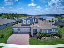 Stunning two-story home with a three-car garage, beautiful landscaping, and a view of the lake at 16768 Sanctuary Dr, Winter Garden, FL 34787