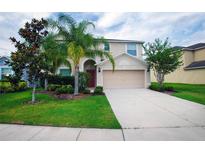 Charming two-story home with landscaped yard, a two-car garage, and a welcoming front entrance at 1748 Thetford Cir, Orlando, FL 32824