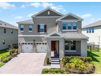 Stunning two-story home with a three-car garage, brick paver driveway, and manicured landscaping at 18309 Oliver Twist Way, Winter Garden, FL 34787