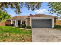 Charming single-story home featuring a brick facade, well-manicured lawn, and an attached two-car garage at 2344 Whispering Maple Dr., Orlando, FL 32837
