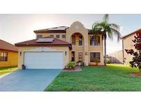Inviting two-story home with a tile roof, lush lawn, and well-manicured landscaping at 3044 Camino Real S Dr, Kissimmee, FL 34744