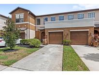 Inviting townhome with a well-manicured lawn, attached two-car garage, and neutral-tone exterior at 3331 Windsor Lake Cir, Sanford, FL 32773