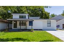 A modern house with a front porch, green lawn, and vibrant landscaping offers great curb appeal at 415 S Lancelot Ave, Orlando, FL 32835