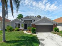 Charming one-story home boasts a manicured lawn, a two car garage, and beautiful landscaping at 468 Jaybee Ave, Davenport, FL 33897