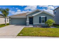 Charming single-story home with a well-maintained lawn, a two-car garage, and stylish exterior finishes at 4990 Four Strand Ct, St Cloud, FL 34769