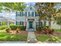 Charming two-story home with blue shutters, an American flag, and a well-manicured front yard at 5032 Beach River Rd, Windermere, FL 34786