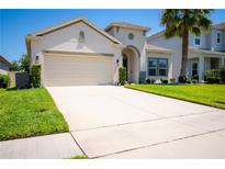Charming home with a spacious two-car garage, lush lawn, and a beautifully landscaped yard at 5306 Rochester Pl, St Cloud, FL 34771
