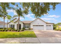 Charming single-story home with a three-car garage, mature landscaping, and a brick paver driveway at 8067 Crushed Pepper Ave, Orlando, FL 32817