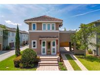 Charming two-story home featuring a lovely portico, arched car port, clay tile roof and beautiful landscaping at 8268 Bellow St, Orlando, FL 32827