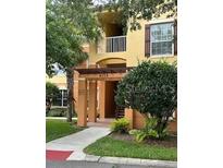 Inviting condo building featuring a charming entrance, balcony, and beautiful landscaping at 8775 Sartori St # 307, Orlando, FL 32829