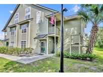 Inviting two-story home featuring classic siding, an American flag, and a well-maintained lawn at 3715 S Lake Orlando Pkwy # 11, Orlando, FL 32808