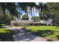 Charming single-story home with a lush green lawn and mature trees, offering a serene and inviting curb appeal at 11923 Lake Butler Blvd, Windermere, FL 34786