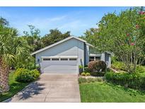 Charming single-story home featuring lush landscaping and a well-maintained two car garage at 125 W Wyndham Ct, Longwood, FL 32779
