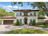 Stately two-story home featuring a terracotta roof, arched windows with flower boxes and lush landscaping at 1361 Palmer Ave., Winter Park, FL 32789