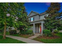 Charming two-story home featuring lush landscaping and a welcoming red front door at 14208 Shocklach Dr, Winter Garden, FL 34787