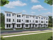 New modern townhouse exterior featuring white siding, black trim and front yard landscaping at 15447 Hamlin Park Drive, Winter Garden, FL 34787