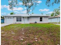 Charming single-story home featuring a metal roof, front lawn, one-car garage, and carport at 160 Chestnut Ave, Orange City, FL 32763