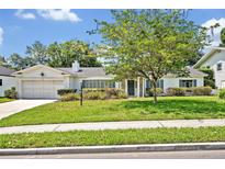 Charming single-story home with a well-manicured lawn, mature tree, and a two-car garage at 2040 Mohawk Trl, Maitland, FL 32751