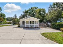 Charming one-story home with a welcoming front porch, manicured lawn, and ample parking space at 205 S Highland Ave, Apopka, FL 32703