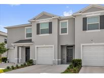 Inviting townhome featuring a gray exterior, attached garage, and well-maintained landscaping at 2224 Tay Wes Dr, St Cloud, FL 34771
