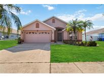 Charming pink single-Gathering home with well-manicured lawn and tropical landscaping at 2481 Deer Creek Blvd, St Cloud, FL 34772