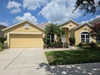 Charming home featuring a lush green lawn, colorful landscaping, and a bright yellow exterior at 2710 Gorst Rd, Winter Garden, FL 34787