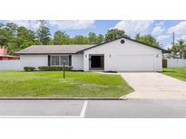 Charming single-story home boasts a well-manicured lawn and a freshly painted exterior, creating instant curb appeal at 2903 Clear Way, Orlando, FL 32805